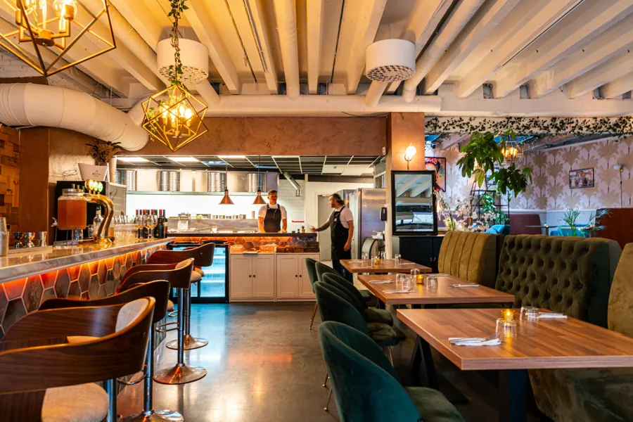 The open kitchen seen from the bar, chefs at the pass